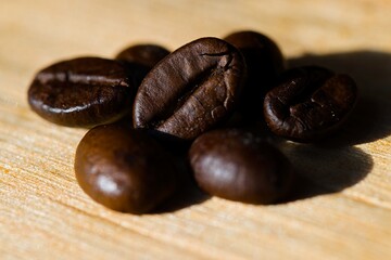 Coffee beans arranged on a piece of raw, freshly split wood.