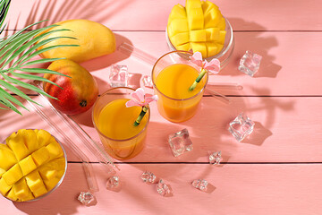 Summer party concept. Homemade cocktail, juice or lemonade with mango slices and ice on sunny...