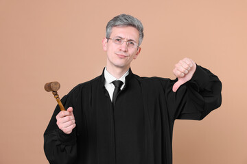 Judge with mallet showing thumbs down on beige background