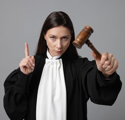 Portrait of judge with mallet on gray background