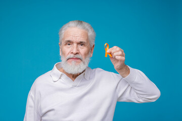 Multiple Sclerosis awareness. Senior man with orange ribbon on light blue background