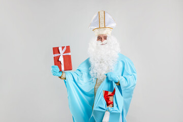 Saint Nicholas with Christmas gifts on gray background