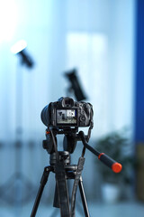 Professional video camera with tripod in modern studio
