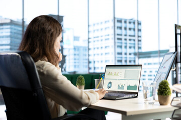 Young entrepreneur with leadership skills creates a financial report, demonstrating her expertise...
