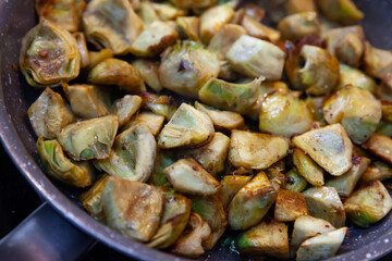 Appetizing artichokes fried in a pan