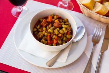 Spanish food Habas a la Catalana, tasty stew of beans in a white ceramic plate