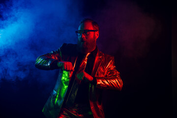 Obraz premium Charismatic gentleman in glowing suit embracing neon night with retro vibes and charm