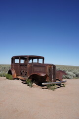 A vintage car sits on Route 66 at Petrified Forest National Park in Arizona, USA