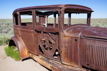 A vintage car sits on Route 66 at Petrified Forest National Park in Arizona, USA