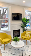 Cozy living room with fireplace, yellow armchairs, and city view, ideal for relaxation and family gatherings