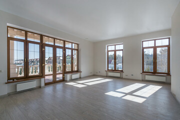 Obraz premium An empty room with the final finish in a luxurious mansion. Panoramic window with double doors and access to the balcony.