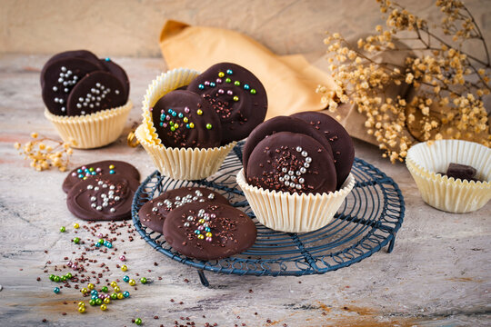 Artisan homemade fine dark chocolate thaler  decorated with colorful sugar pearls in muffin moulds