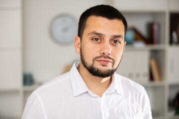 Obraz premium Portrait of caucasian man standing in office and looking at camera. Portrait of male office manager.