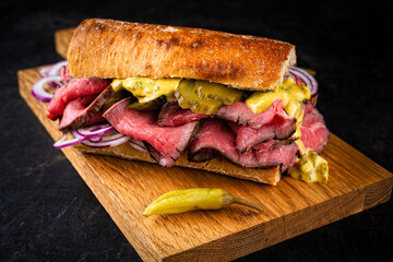 Traditional sliced cold cuts roast beef sandwich with onion, gherkin and onion