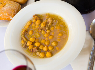 Traditional Catalan stewed chickpea with iberian bacon served with red wine..