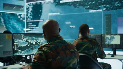 Soldier in a secure environment ensuring data analysis and processing, gathering intelligence for strategic planning to ensure a successful defense mission. Secret service activity. Camera B.