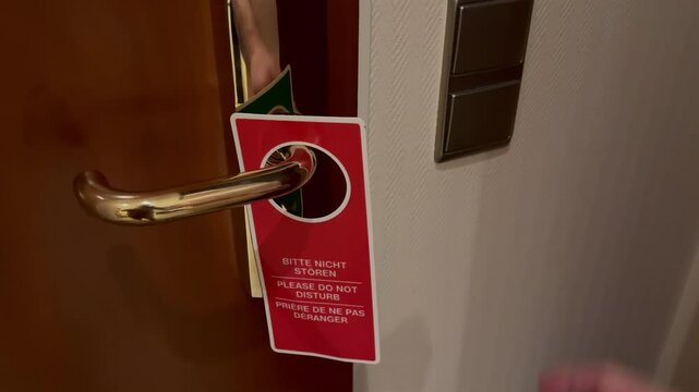 Bitte nicht st&ouml;ren mit Licht ausA sign "Do not disturb" is hung on the door handle of a hotel room and then two light switches are turned off