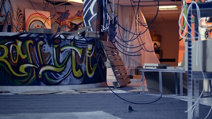Empty destroyed infrastructure with graffiti street art on walls, concept of alternative lifestyle. Messy base of operations used by hooligans to hangout and commit illegal activities, panning shot