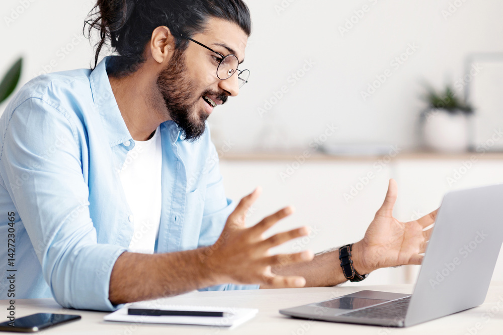 Poster young arab freelancer guy making video call with laptop at home, having web conference with clients.