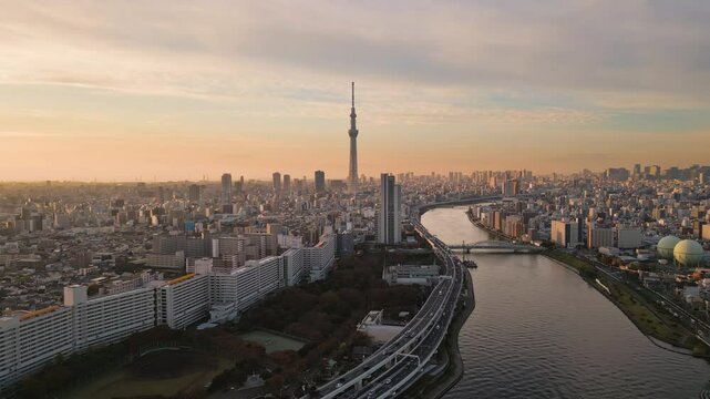tokyo city skyline aerial view drone pan over skytree tower asakusa district seen from arakawa river at sunrise dawn
