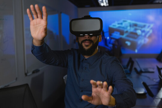 Man wearing VR headset in conference room interacting with interface on projection screen