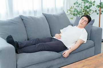 ソファーで昼寝をする男性