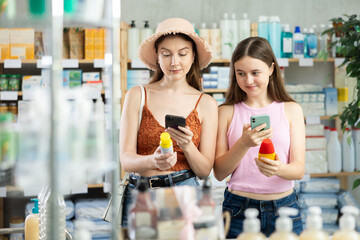 Daughter and mother in summer clothes scans code on sunscreen to check the expiration date
