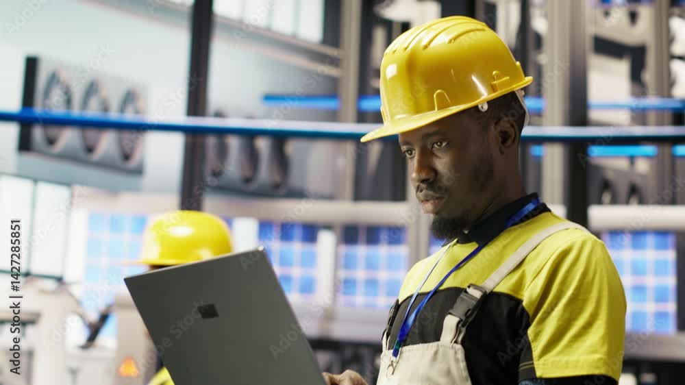 Poster engineer in smart factory does maintenance using laptop software, analyzing iot sensor data. industr