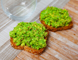Appetizing toast with guacamole served on plate for breakfast