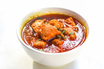 a bowl of spicy chicken curry isolated on white background