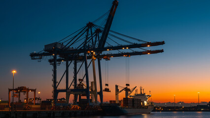 Obraz premium Harbor Cranes Loading Ship at Blue Hour 