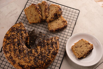 Slice banana cake sprinkled with chocolate on a cooling rack. bolu pisang.