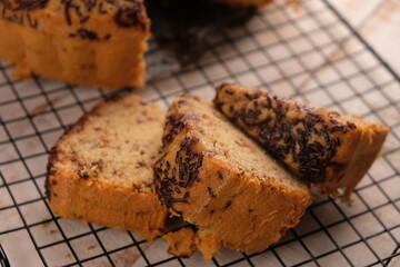 Slice banana cake sprinkled with chocolate on a cooling rack. bolu pisang.