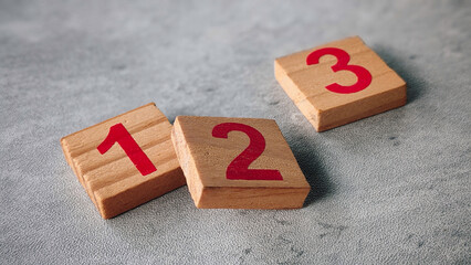 Wooden Number Blocks 1, 2, 3 Arranged on Gray Surface