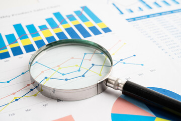 Magnifying glass on spreadsheet and graph paper. Financial data economy, Business.