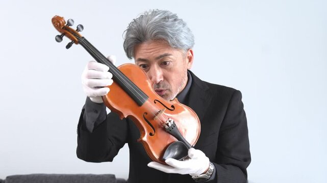 バイオリンを調べる男性