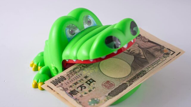 1万円札を咥えるワニ