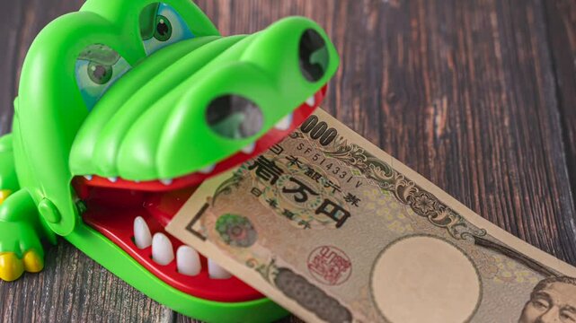 1万円札を咥えるワニ