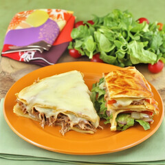 Plate of sandwich accompanied by salad in the background representing a quick and nutritious meal ideal for busy lives