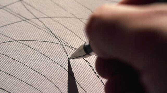Hand with a pen draws a line on an abstract canvas, the camera follows the hand. Macro shooting