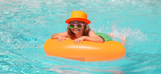 Summer vacation on tropical beach. Child boy swim with float ring in swimming pool. Kids summer...