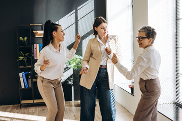 Businesswomen dancing in the office celebrating success