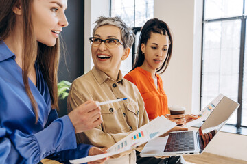Businesswomen collaborating and analyzing financial data in office meeting