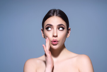 Surprised shocked young girl isolated over gray studio background. Close up shot of emotive shocked...