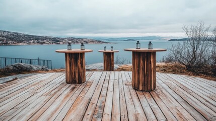 Rustic wooden tables on a waterfront deck, featuring lanterns.