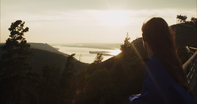 Woman observing sunset over mountain valley landscape