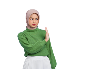 Beautiful annoyed Asian woman in green sweater makes stop gesture, demonstrates rejection isolated on transparent background
