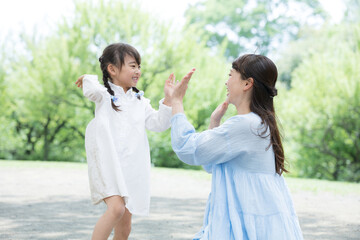 Image of parent and child (mother and daughter) looking at each other with beautiful fresh greenery...