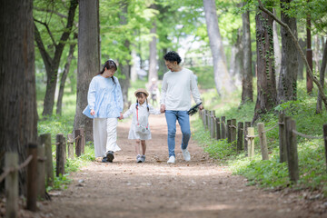 Obraz premium : 家族で夏休みの虫探し！春夏のお出かけやアウトドアレジャーのイメージ 旅行で森で遊ぶ楽しそうなファミリー 正面