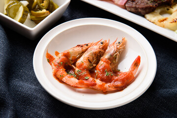Three grilled shrimp on a white plate
